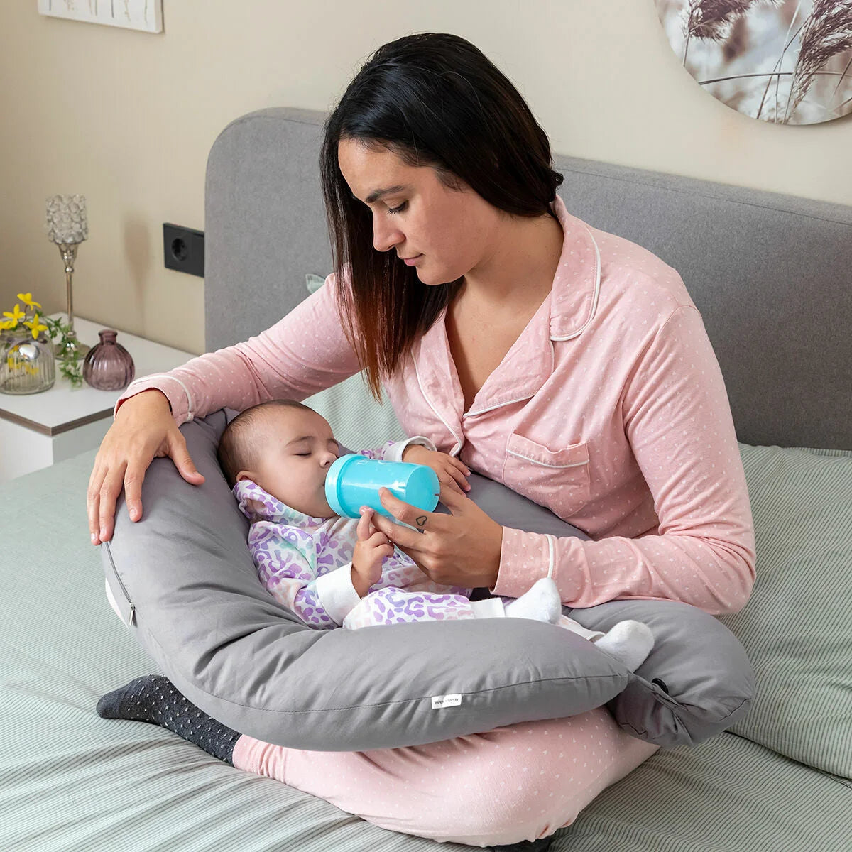 Mutter füttert ihr Baby auf dem grauen Brellow Stillkissen