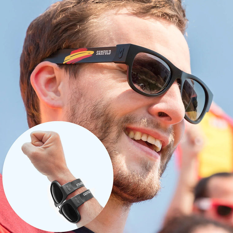 Mann mit schwarzer Sunfold Spain Falt-Sonnenbrille am Handgelenk