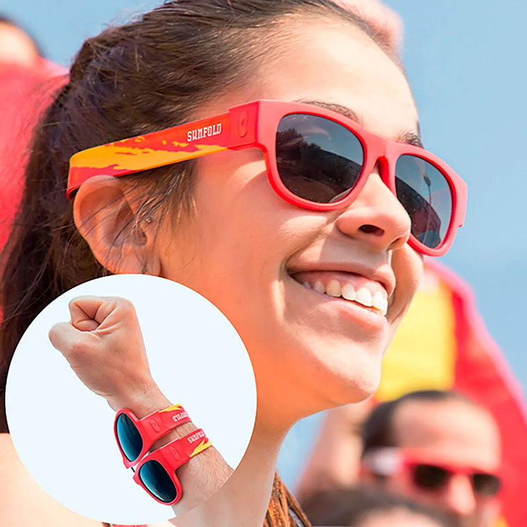 Frau mit roter Sunfold Spain Falt-Sonnenbrille am Handgelenk