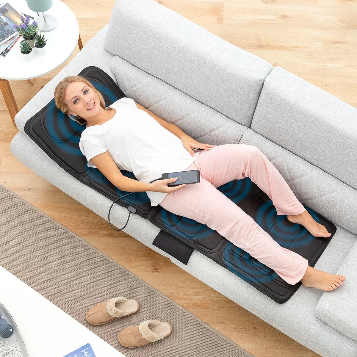 Frau nutzt Vhemat Vibrations-Massagematte auf dem Sofa